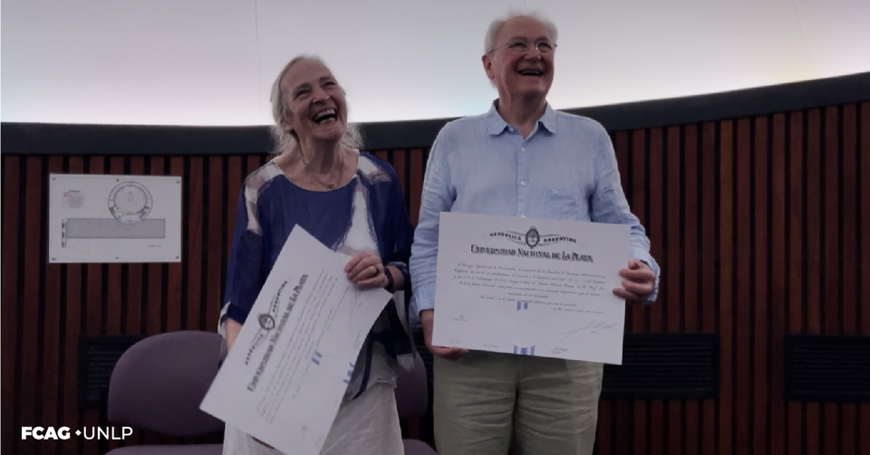 En la imagen se ve a Elena y Roberto Terlevich sosteniendo sus Diplomas Honoris Causa, sonriendo ampliamente. En el Planetario UNLP