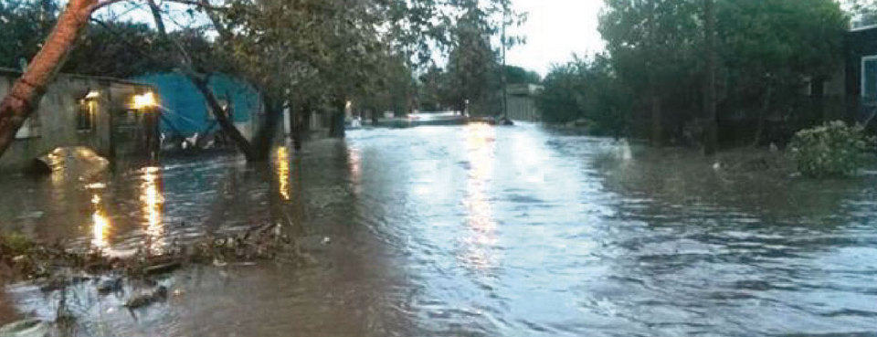 La imagen corresponde a una vista general de una de las calles del barrio Villa Elvira, cubierta de agua que desbordó del arroyo Maldonado.